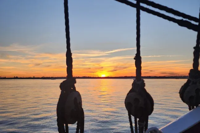a group of people standing next to a body of water