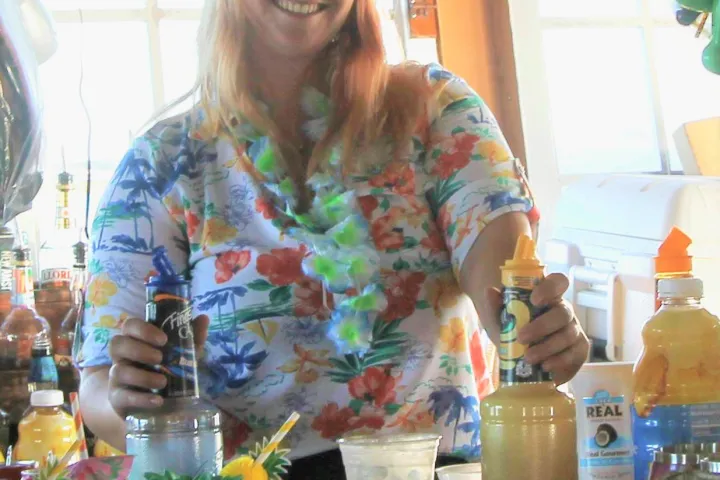 a person sitting at a table with a vase of flowers