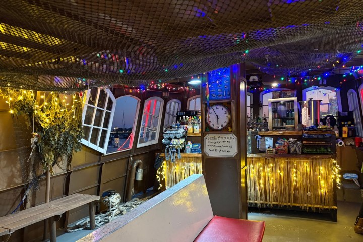 Cozy room with a bar, decorated with string lights and nautical elements.